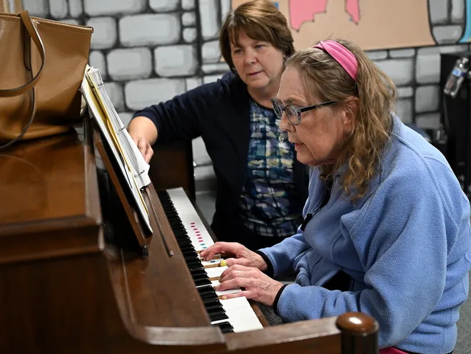 Board-certified music therapist Susan Gregory conducts a music therapy session with client Lisa Pirscher.